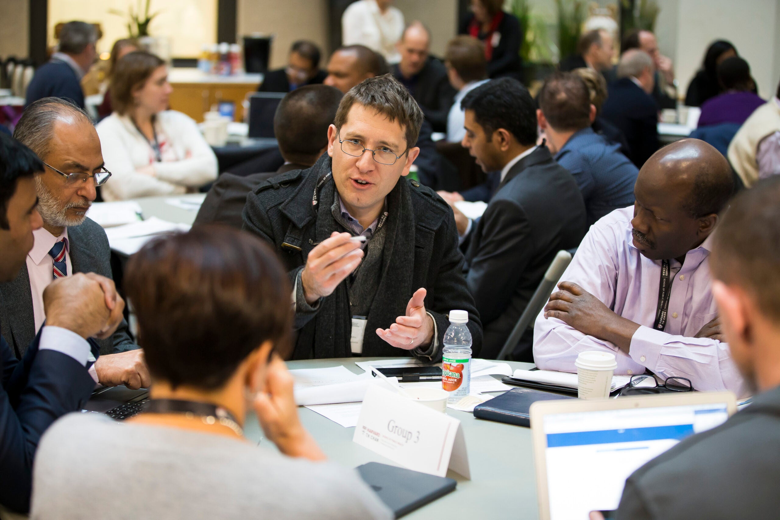 Professionals in a Harvard Chan classroom collaborating on a group project