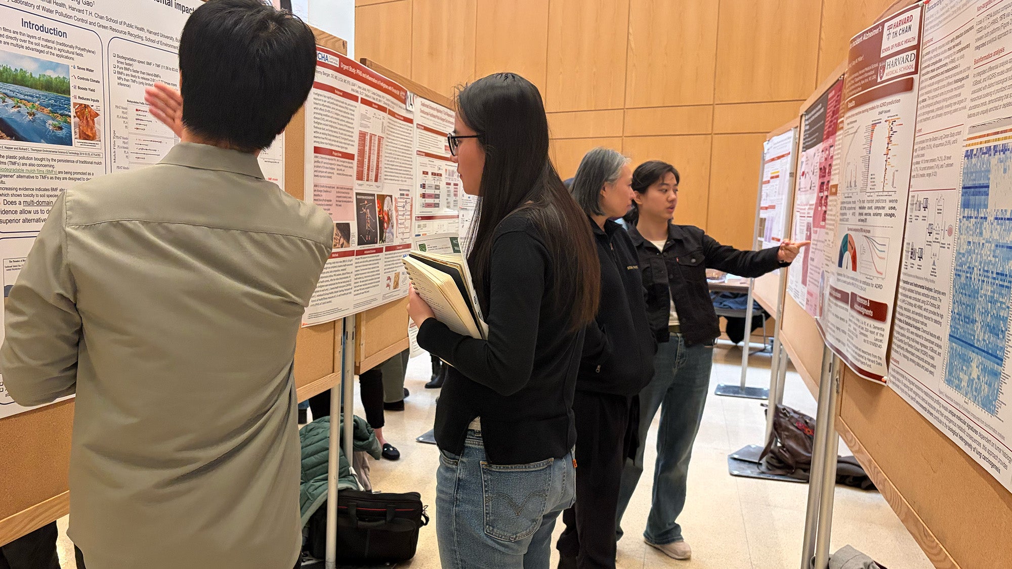 People stand in front of research poster displays.
