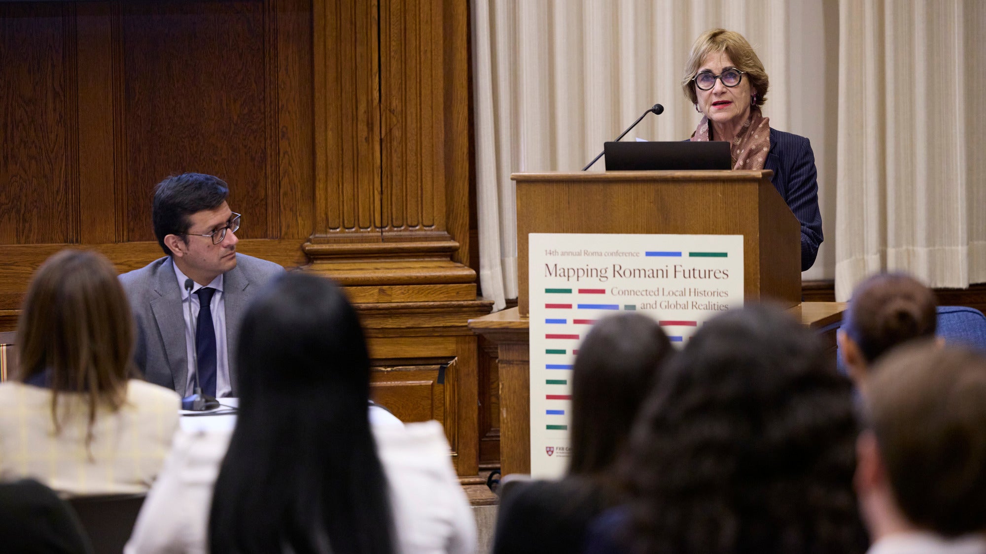 Jacqueline Bhabha speaking at a podium in front of an audience