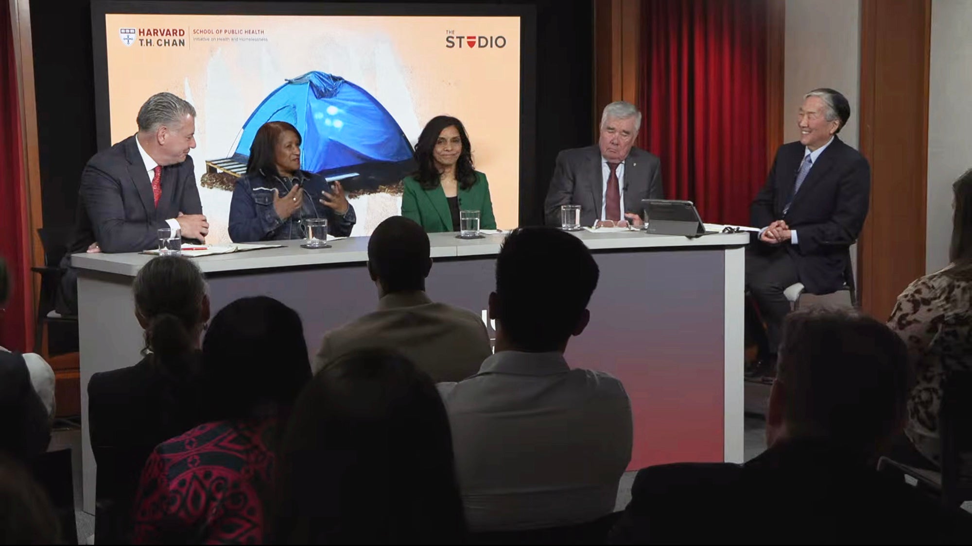 Panelists and moderator sitting behind a desk