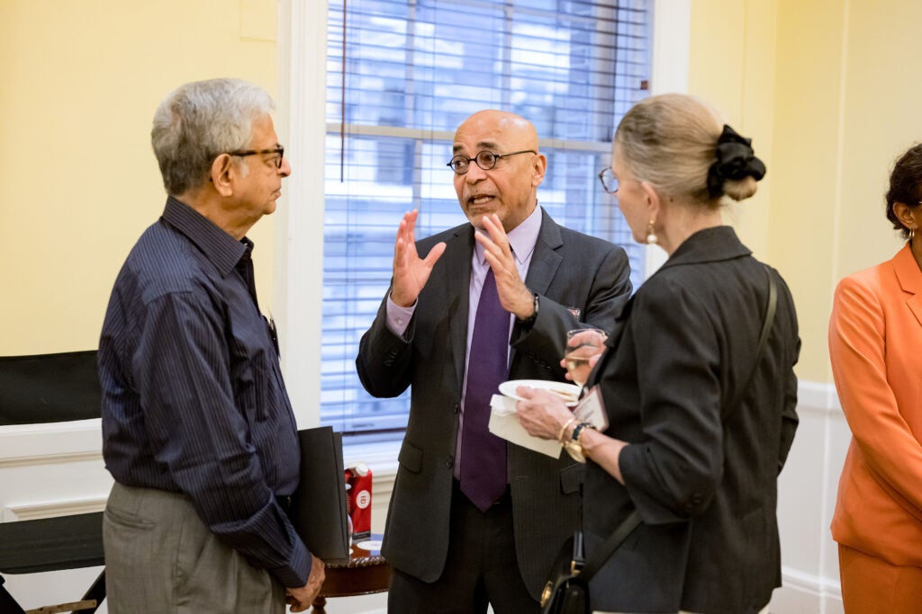 Vish Viswanath speaks animatedly with two guests.