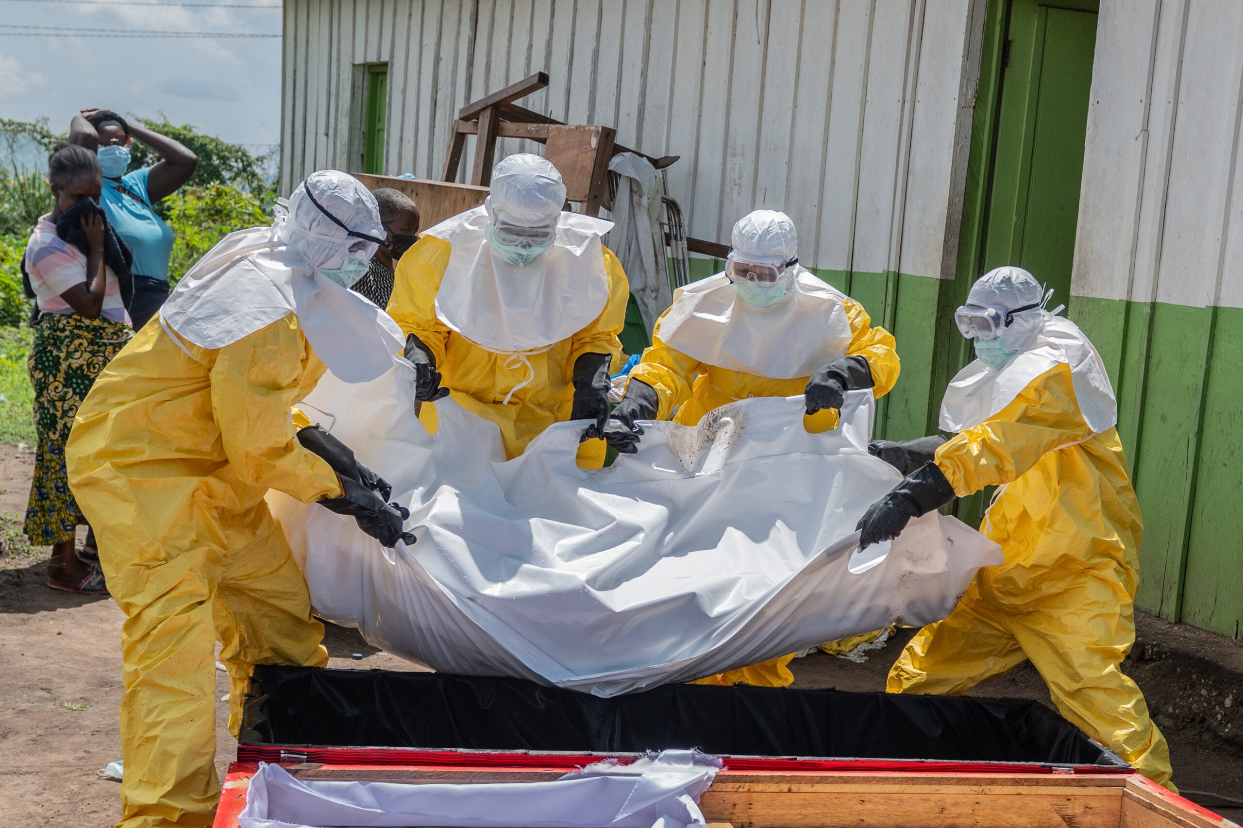 Red Cross workers carry the body of a person who died of Ebola into a coffin at a health center in Rwampara, Congo, Wednesday, May 20, 2026.