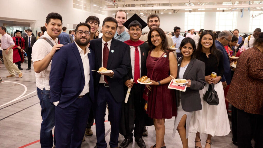 A graduate poses with his family at reception