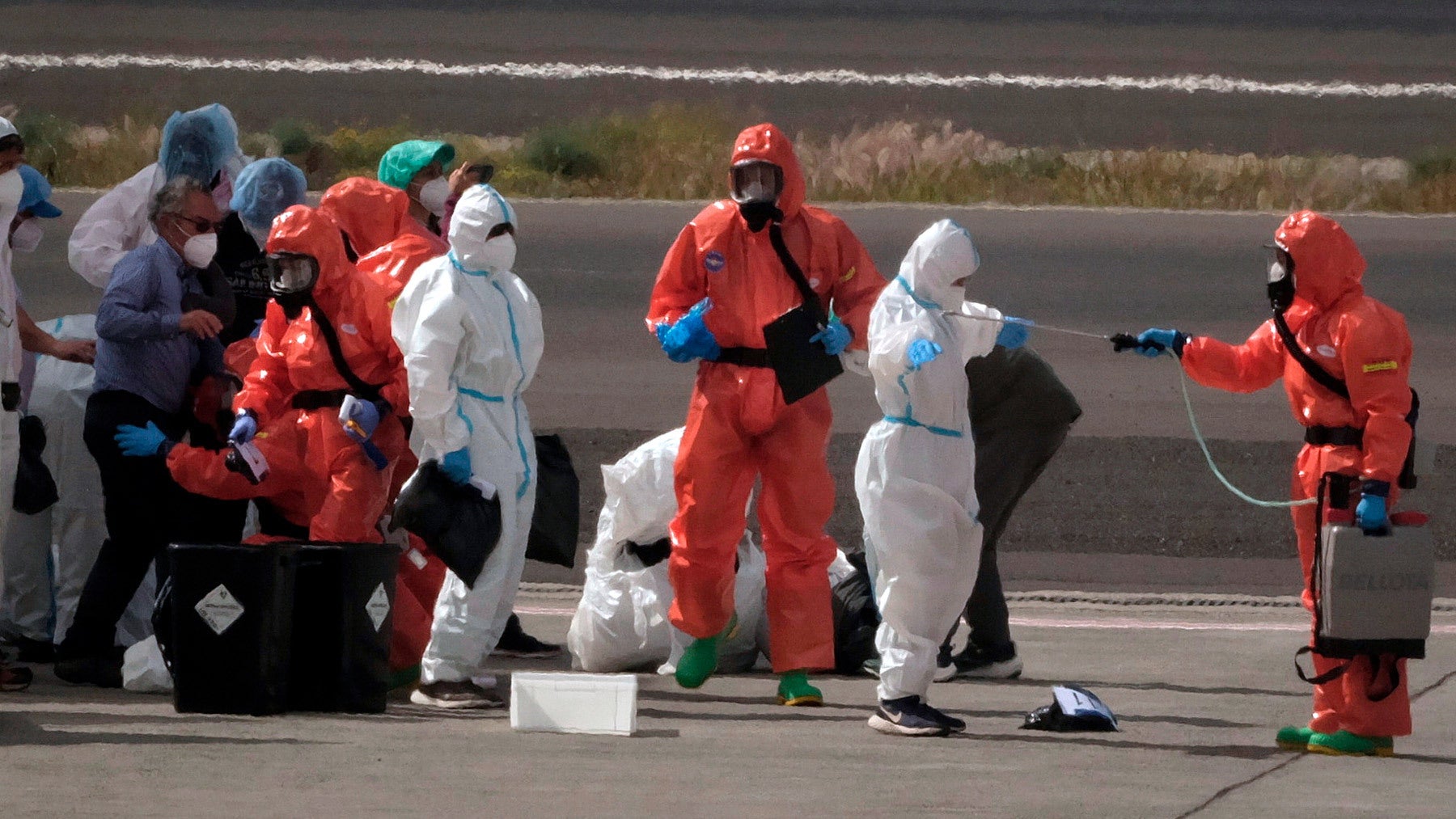 Passengers are sprayed with disinfectant by Spanish government officials after disembarking from the hantavirus-stricken cruise ship MV Hondius in the Canary Islands, Spain, on May 10. AP Photo / Arturo Rodriguez