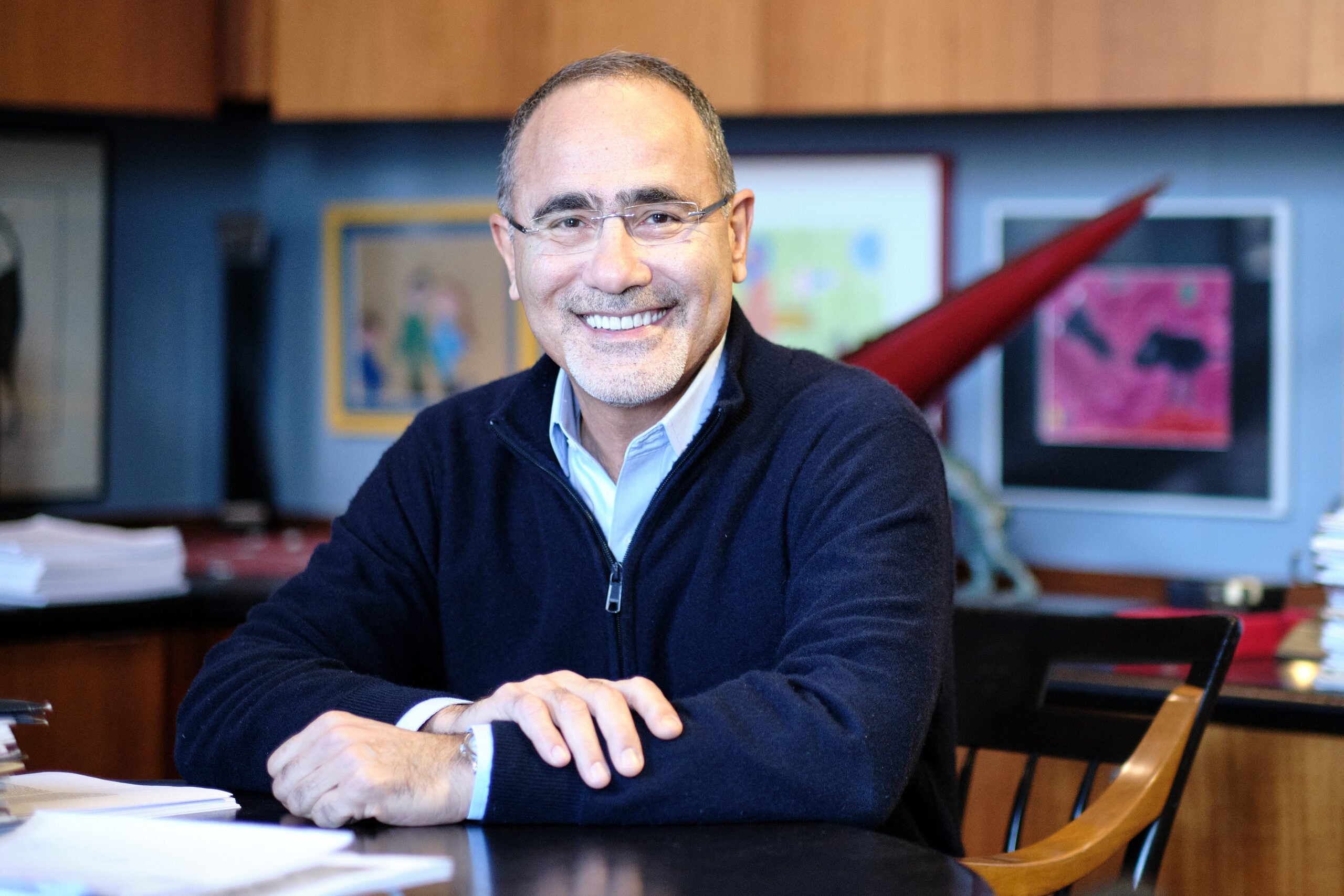 Dr. Hotamisligil sitting at desk in navy sweater