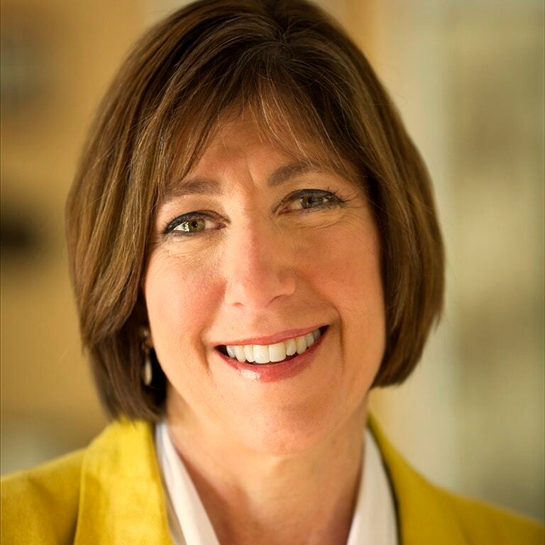 Headshot of Sheryl Gay Stolberg in a yellow blazer and white shirt