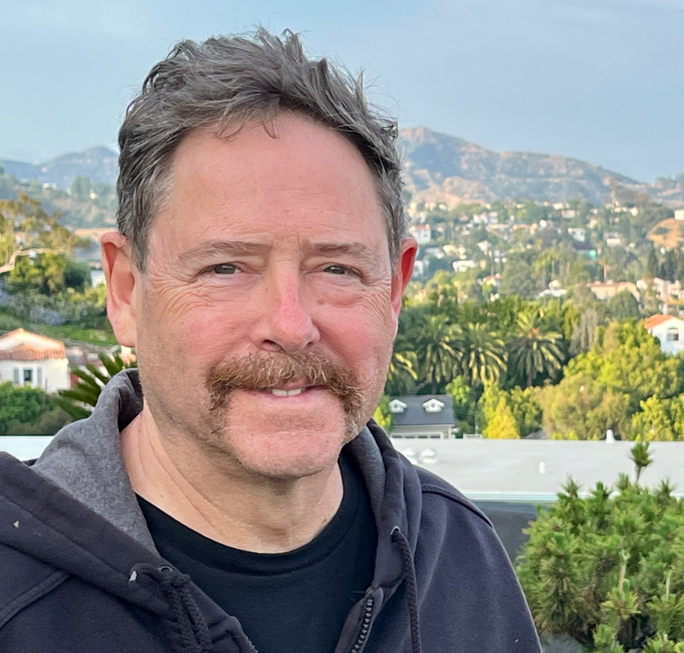 Scott Hensley pictured in a grey sweatshirt from the shoulders up.