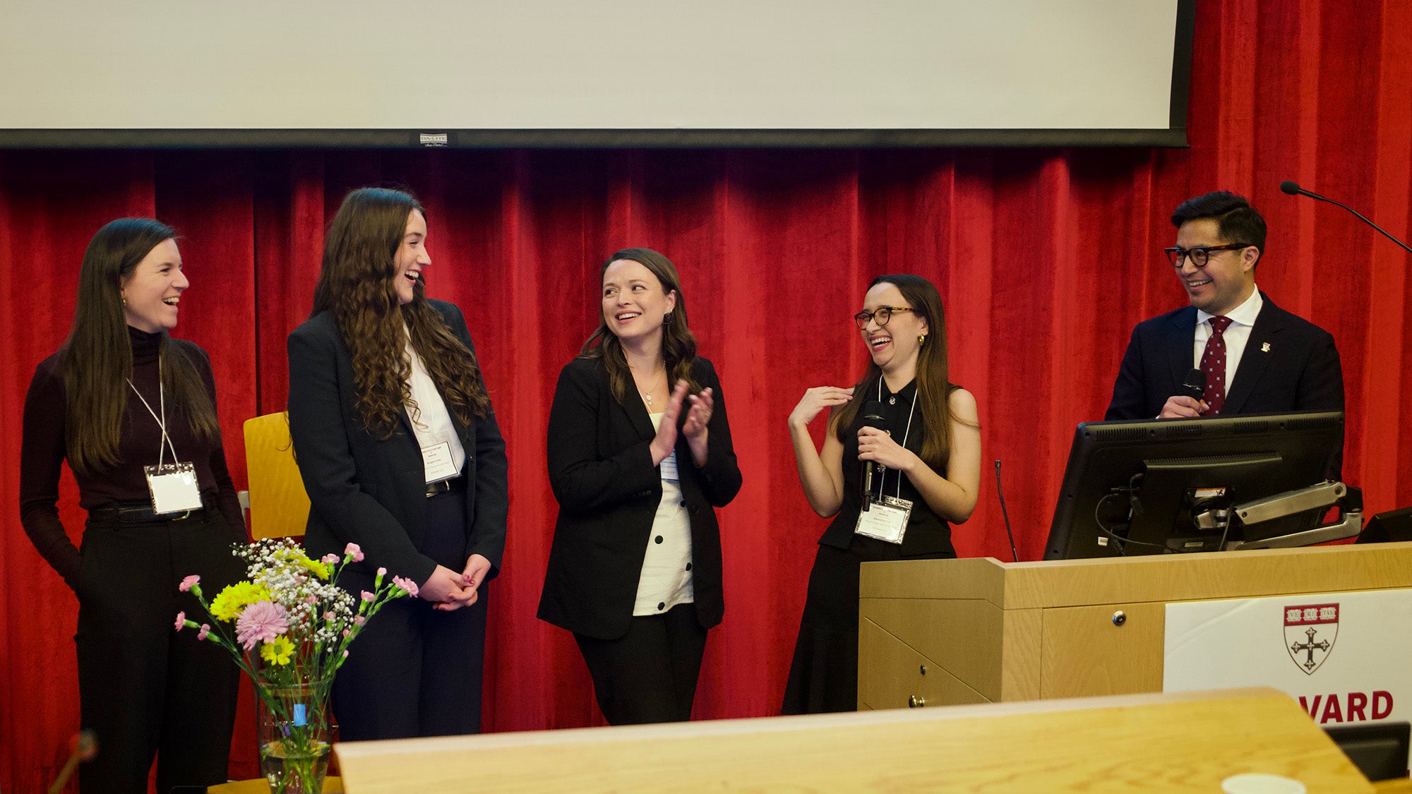 Four people standing by a podium, smiling