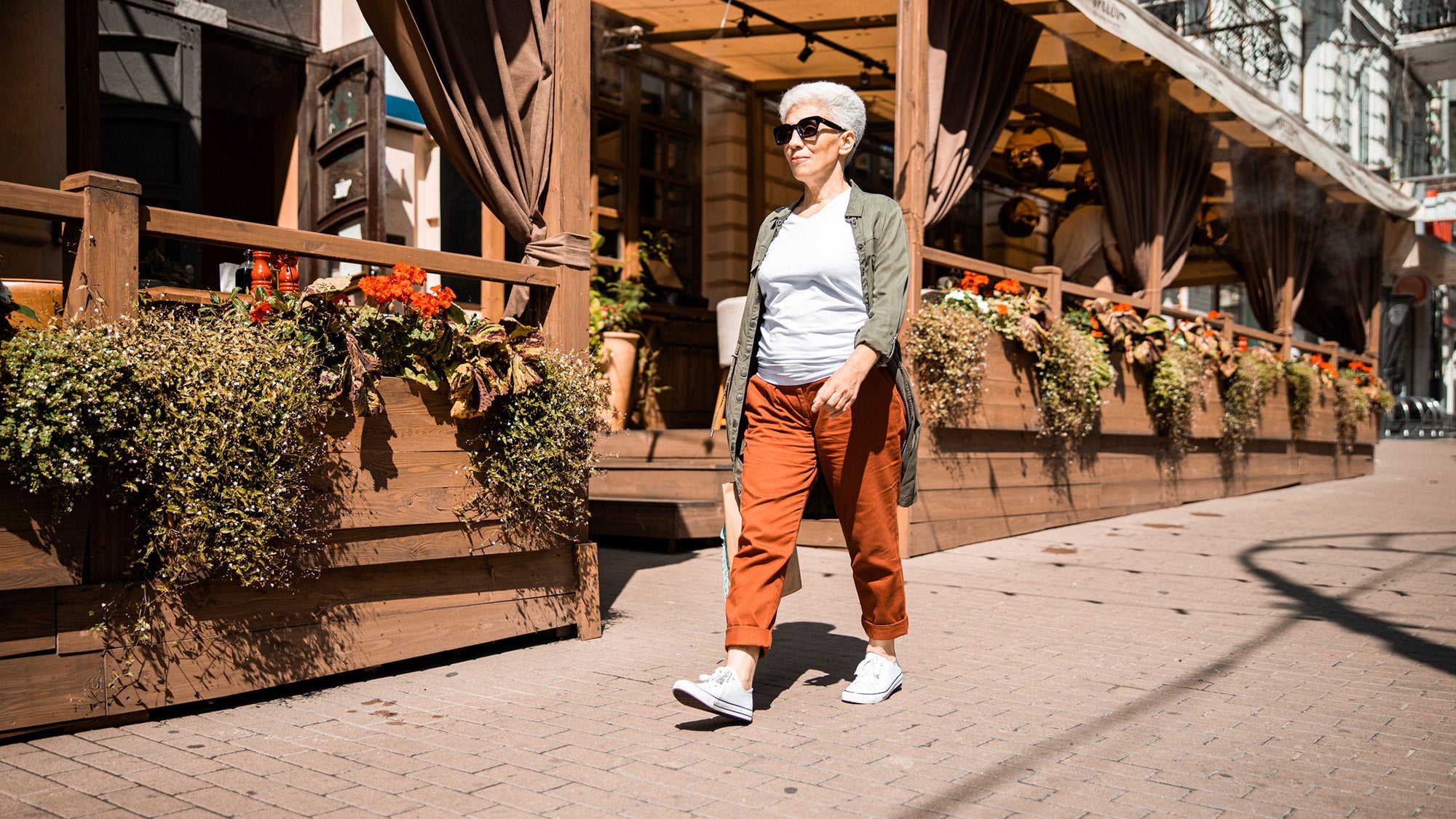An older woman walking on a city sidewalk