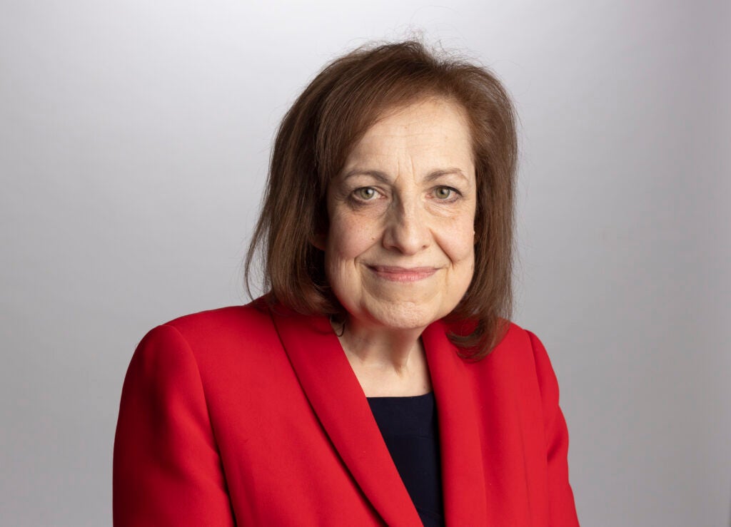 Sarah Neville is pictured from the shoulders up wearing a red blazer