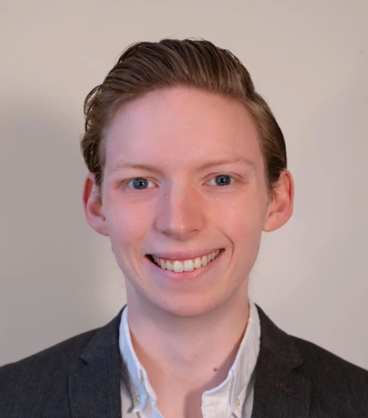 Daniel Payne is featured from the shoulders up in a blazer and white shirt.