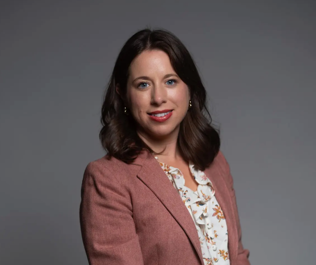 Amanda Seitz is pictured from the waist up in a blazer and patterned blouse.