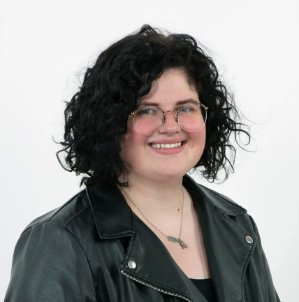 Cris Villalonga-Vivoni is pictured from the shoulders up wearing a black leather jacket and glasses.