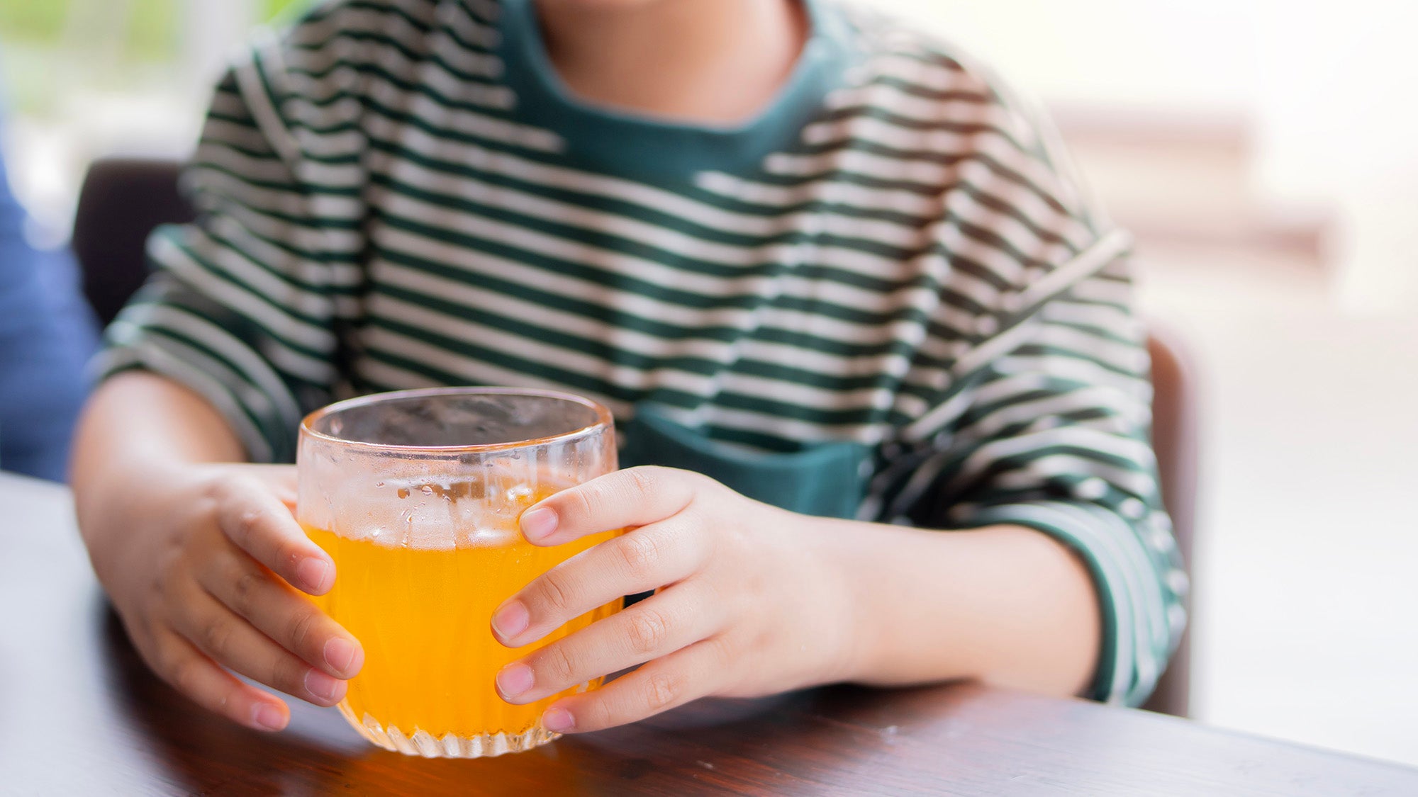 child holding juice glass