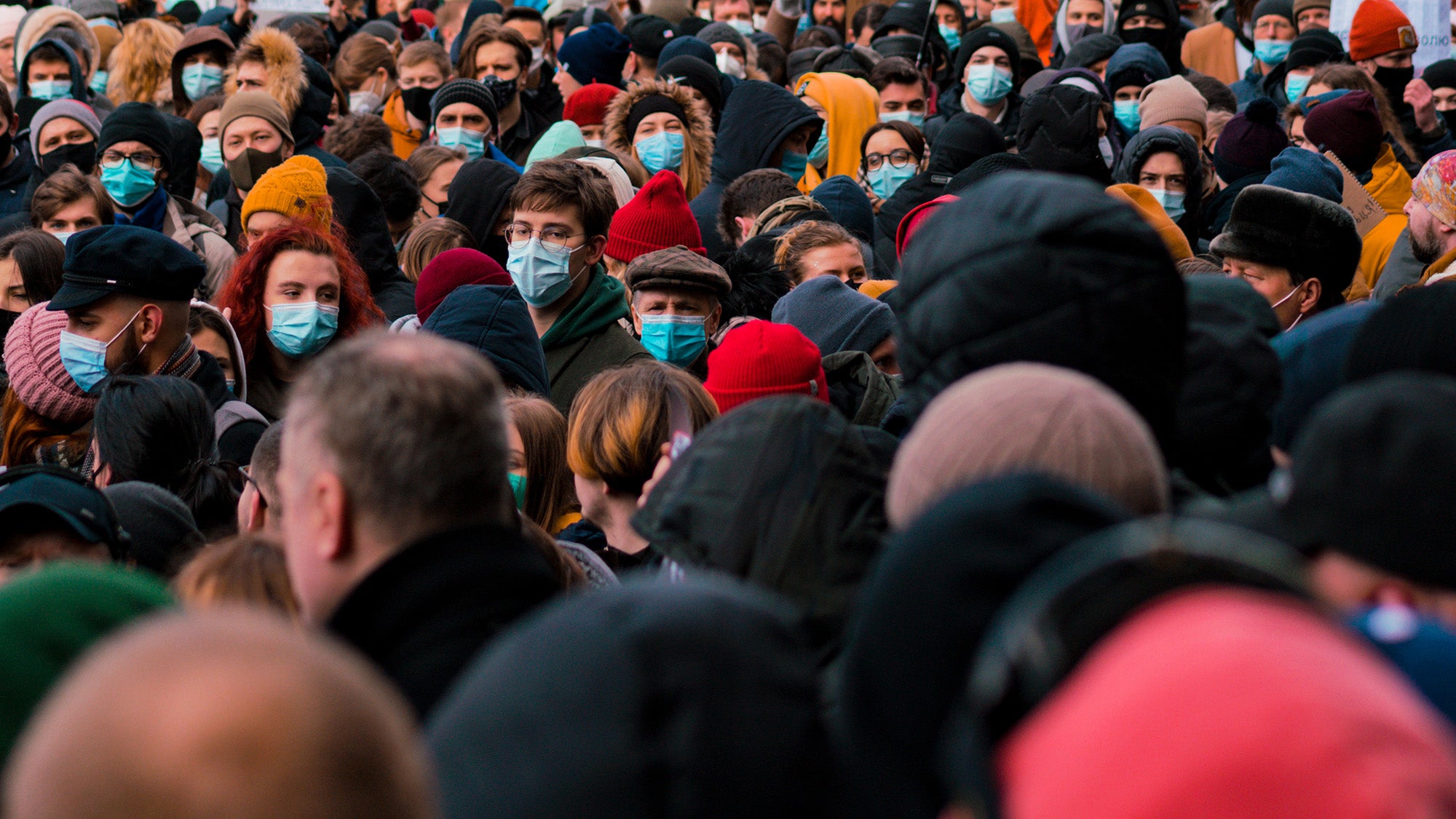 A crowd of people on the street wearing face masks during COVID-19 pandemic