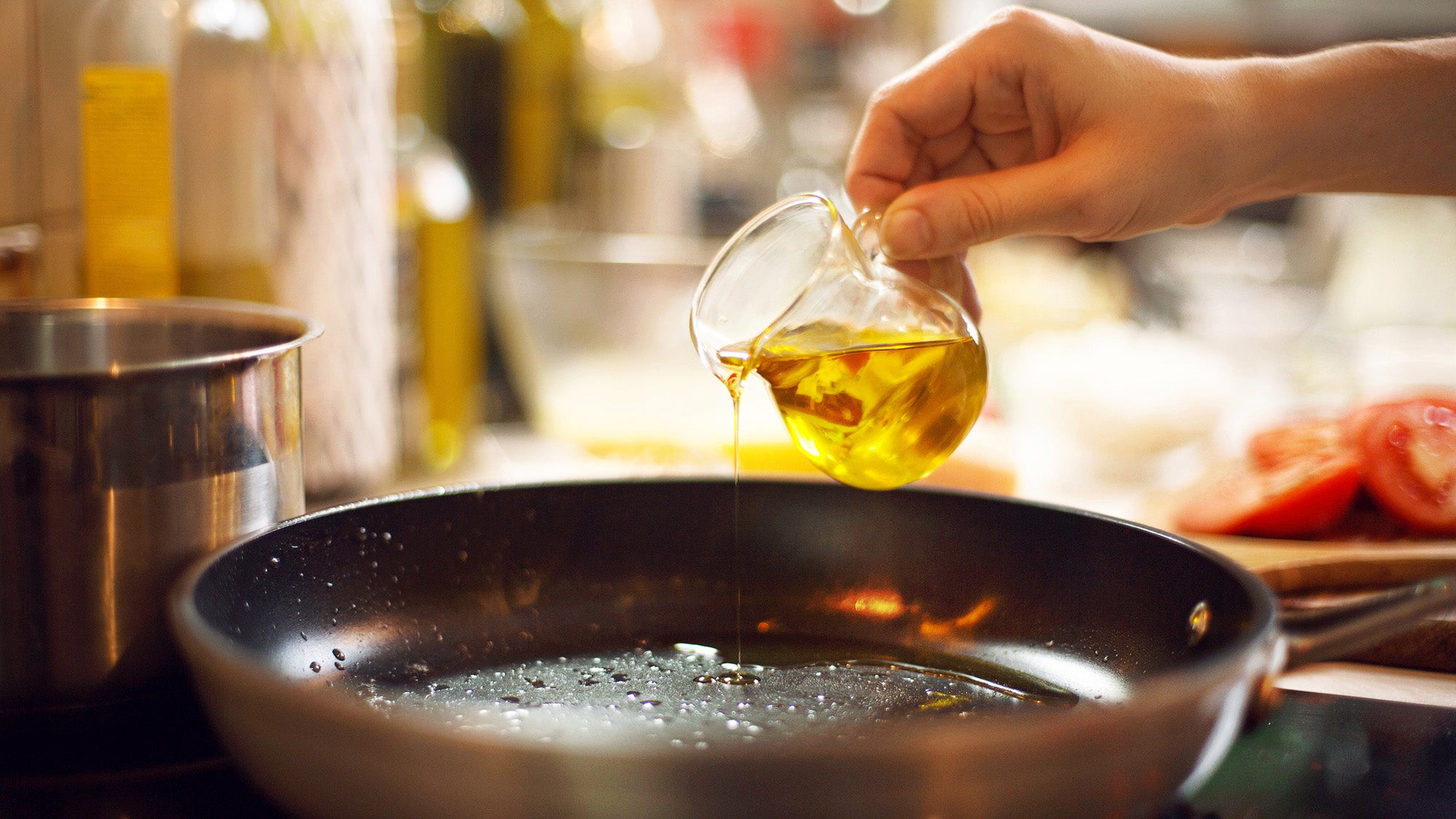 cook pours oil on a skillet