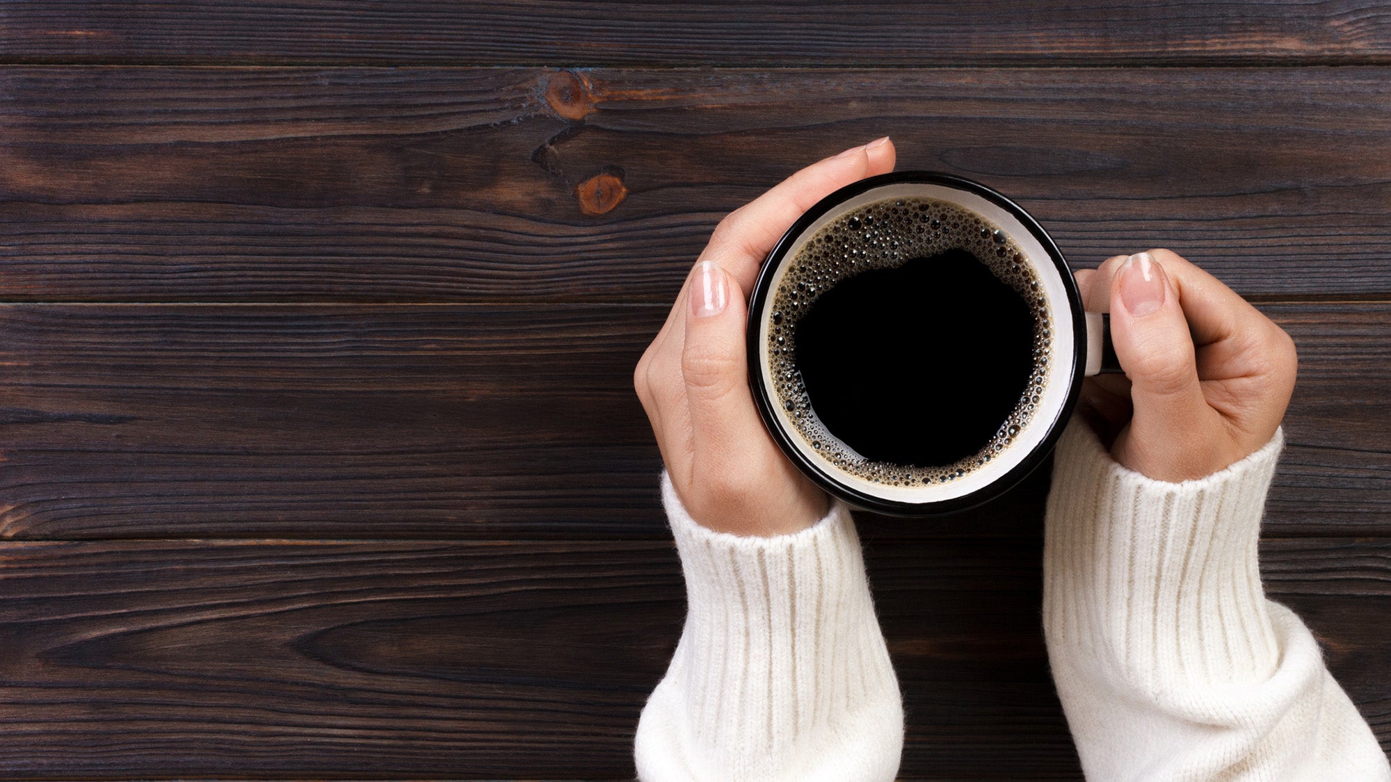 woman's hands holding coffee cup