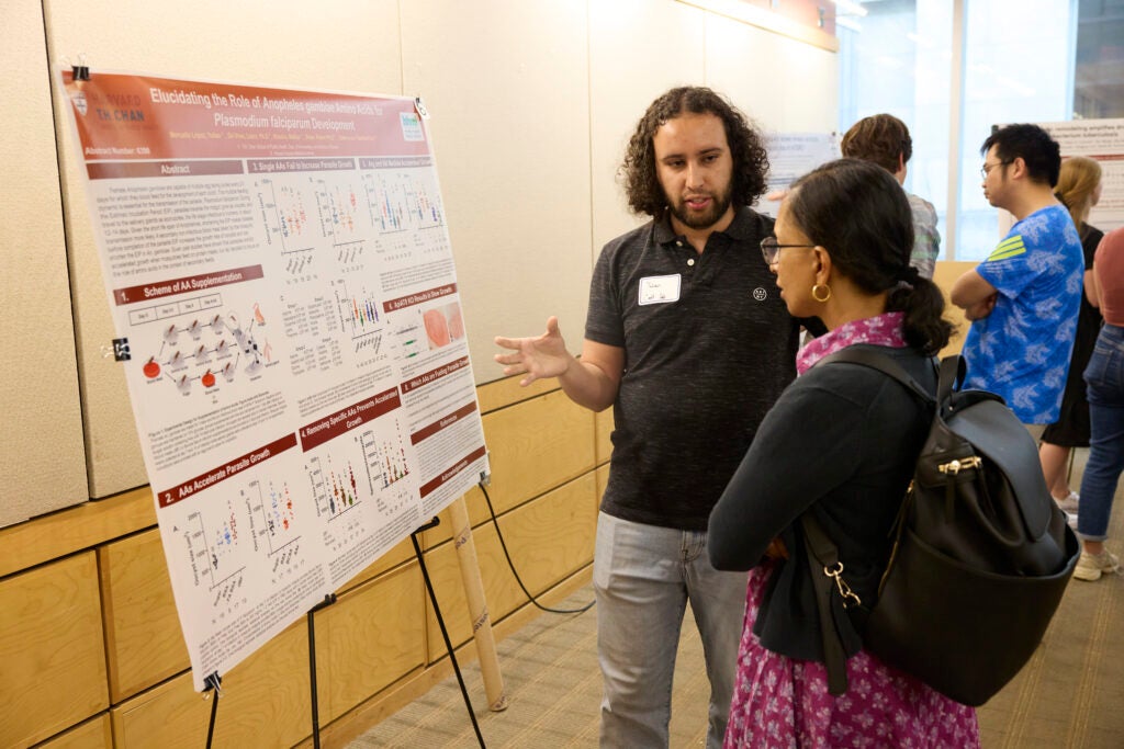 A researcher chats with a fellow poster session attendee about his work.
