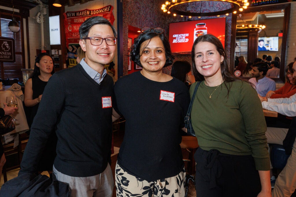 One man and two women pose for a photo at Dillions bar in NYC.