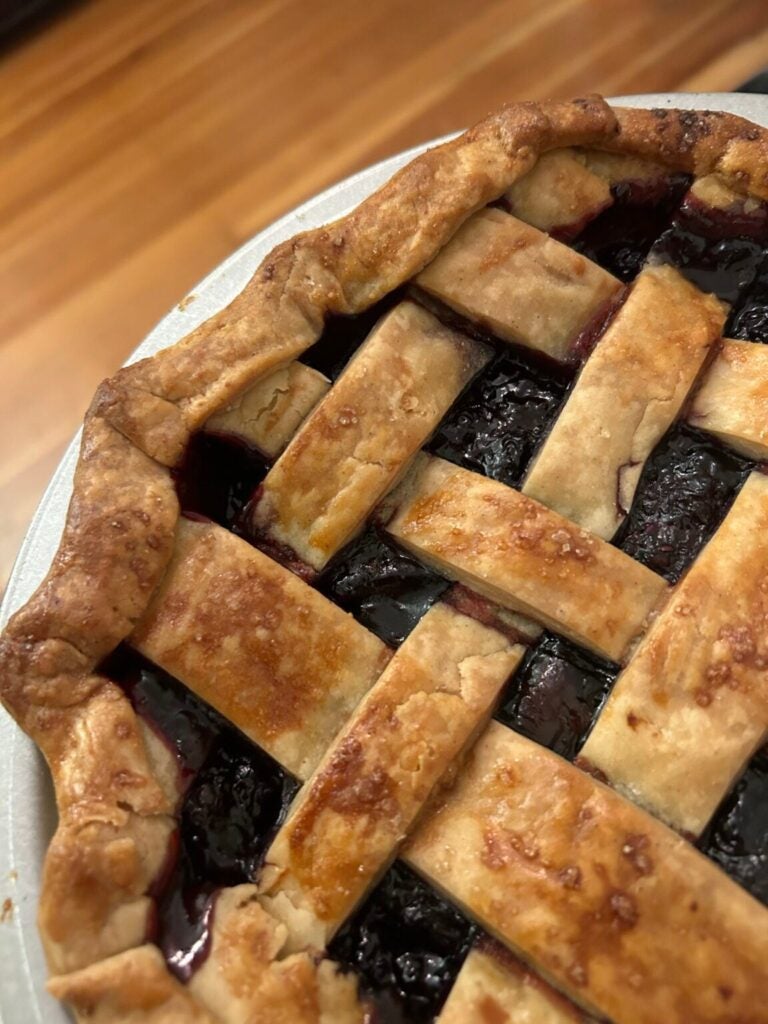 A blackberry pie on a white plate.