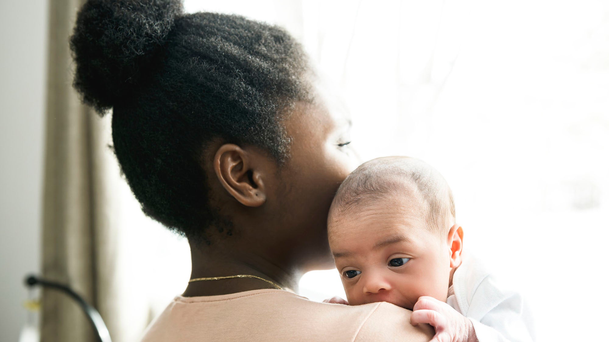 Mother holding baby over shoulder