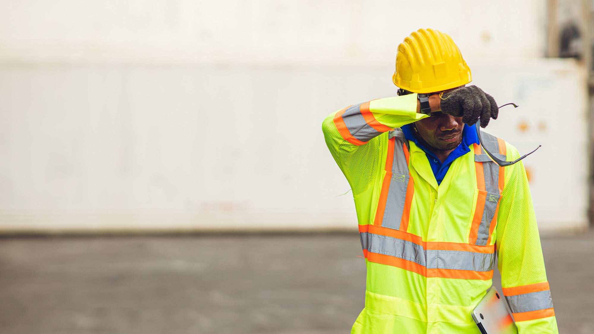Worker in hard hat wiping brow