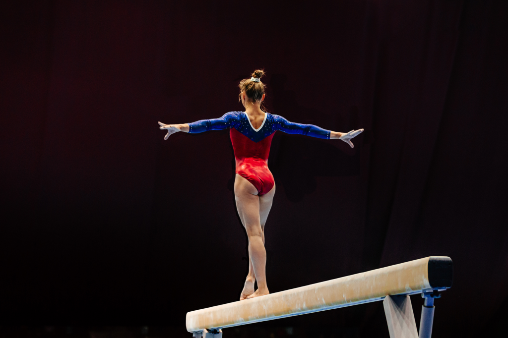 female gymnast athlete balancing on balance beam gymnastics,
