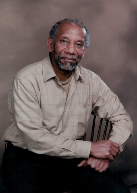 Portrait of Felton Tony James Earls seated, wearing a grey shirt.