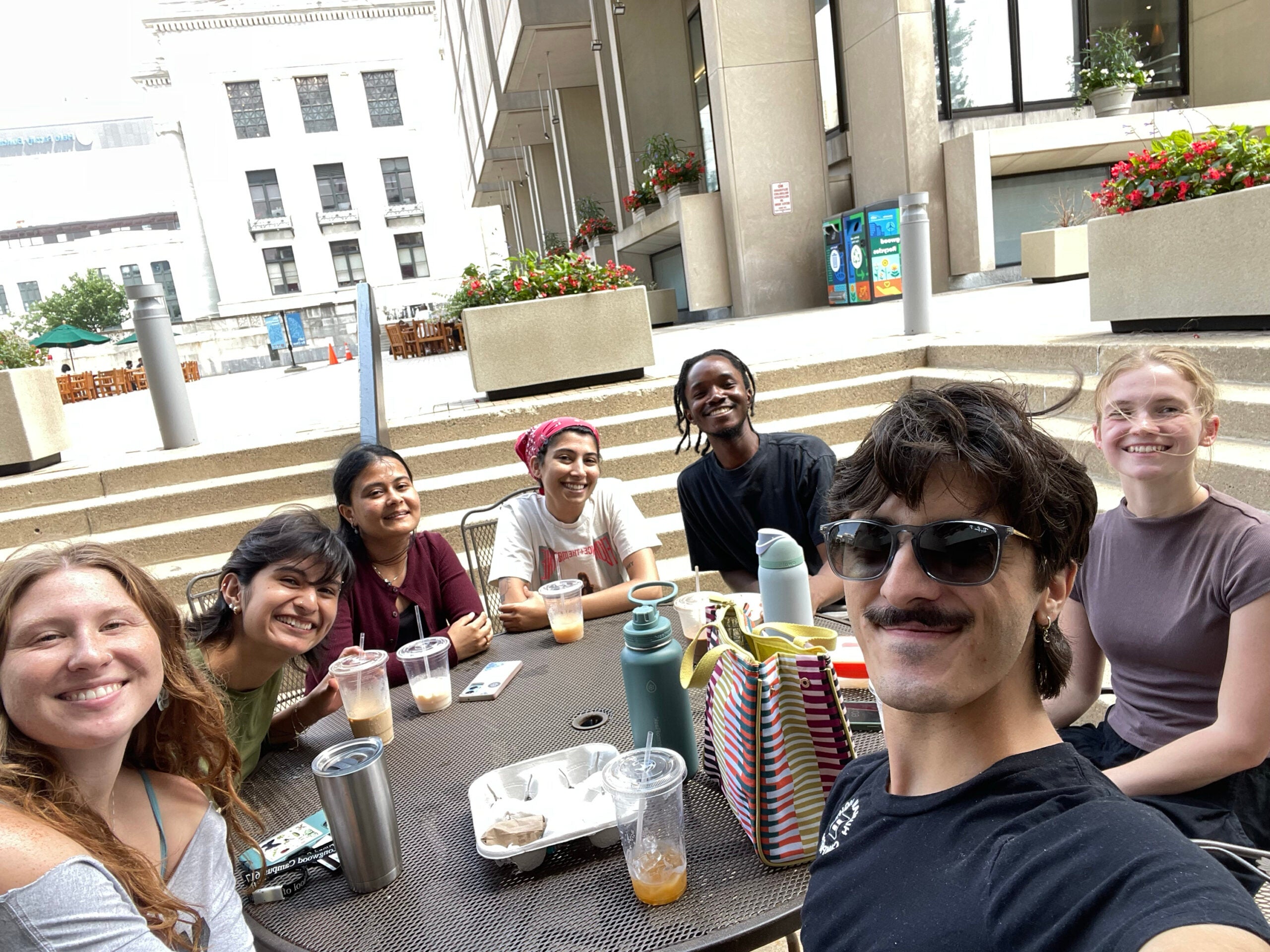 Jamie Momoh eating at a circular table on campus with a group of friends