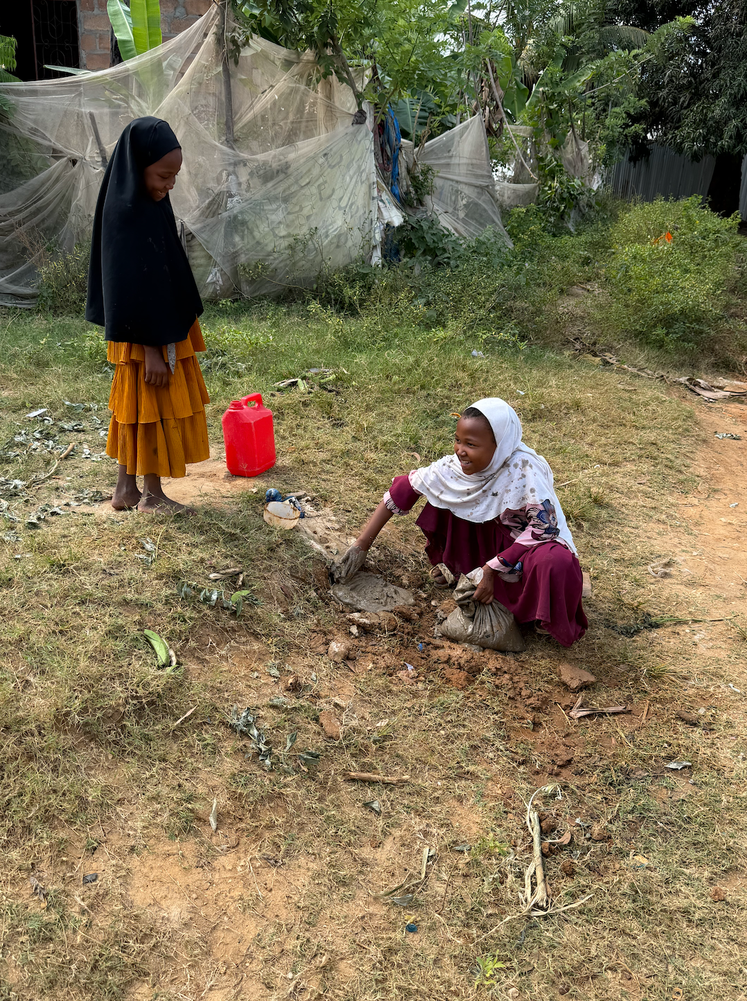 Five year old Khadija builds a drinking basin for the chickens. Photo: Farwa Akbari