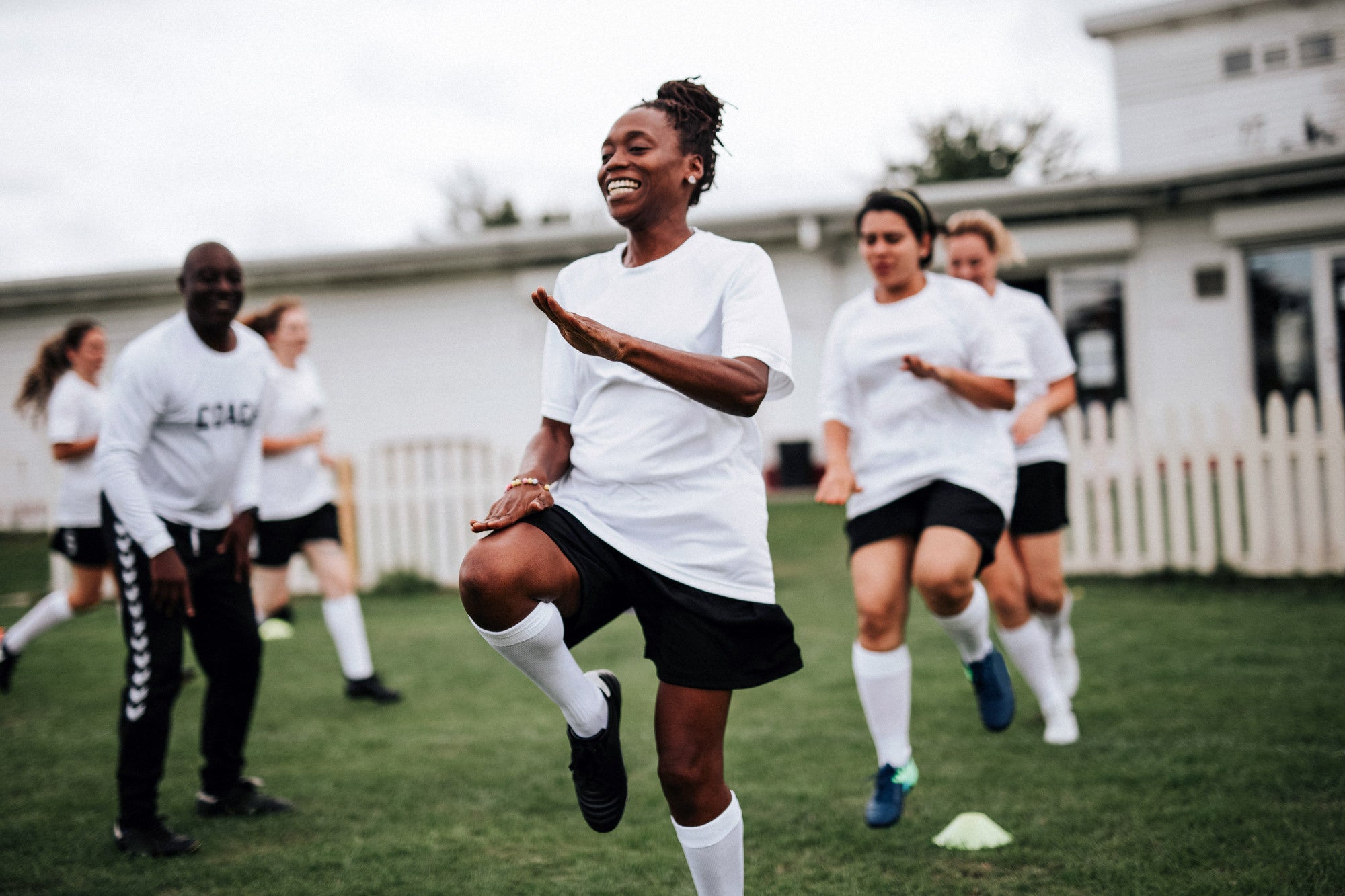 Female soccer players smile during practice