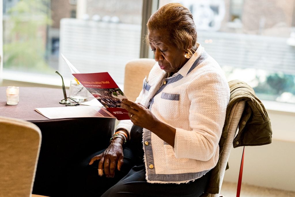 A guest sits at a table, focused on reading a C-CHANGE brochure. 