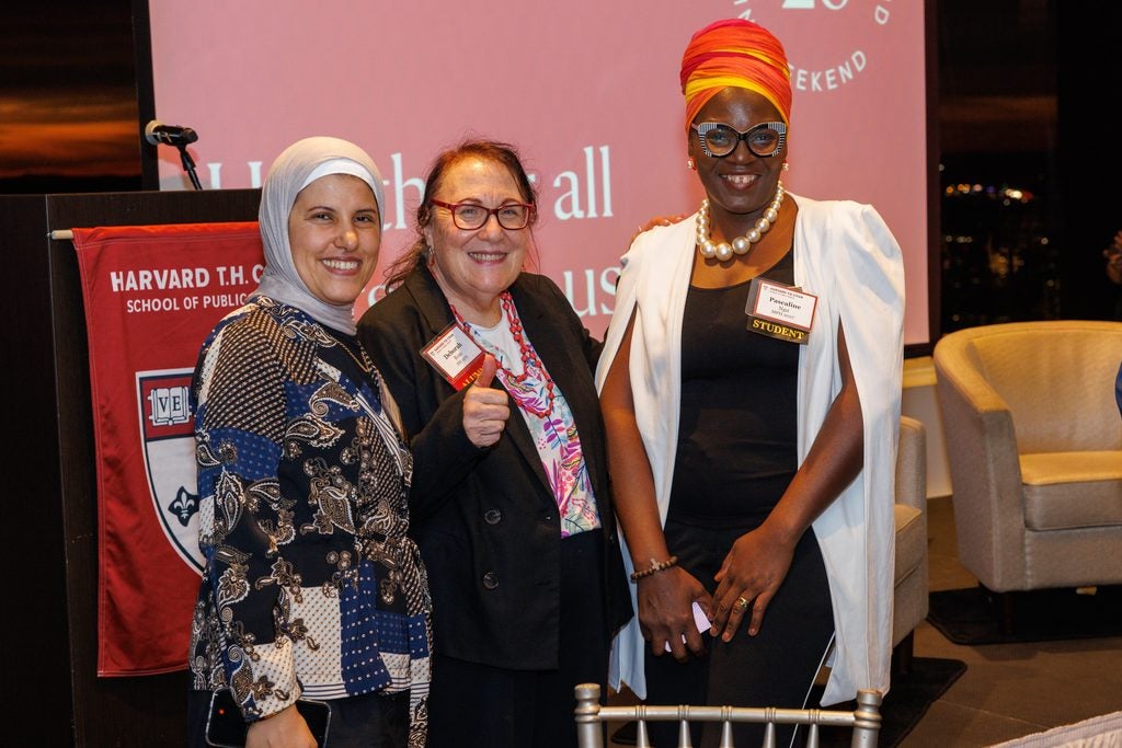 Alumna Deborah Rose poses with two students. 