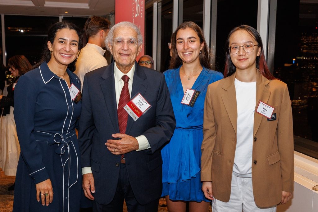 Steve Shama poses with a group of three students. 