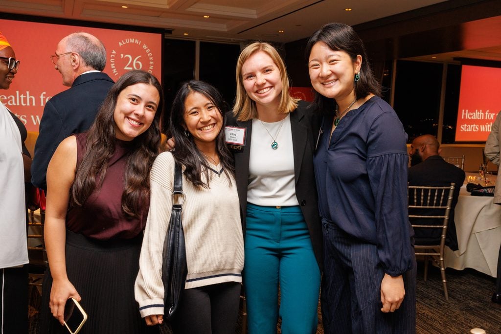 Four students, smiling together. 
